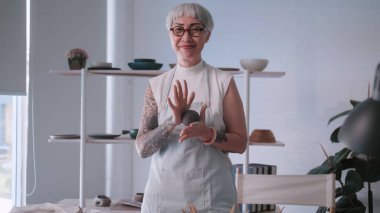 Evde çömlekçilik yapmaktan hoşlanan Asyalı yaşlı kadın. Bir kadın seramikçi stüdyoda yeni çömlekler yapıyor..