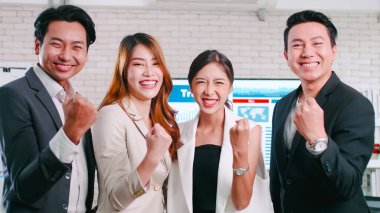 Asyalı iş adamları toplantı odasında başarıyı kutluyor..