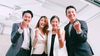 Asyalı iş adamları toplantı odasında başarıyı kutluyor..