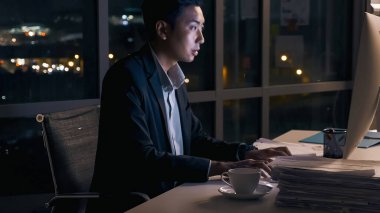 Gece geç saatlere kadar ofisindeki iş projelerinin analizine konsantre olan genç bir işadamı..