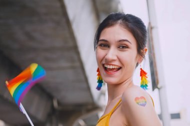 Gökkuşağı dövmeli genç bir kadın. Gurur yürüyüşünde homoseksüelliğin sembollerini gösteriyor..