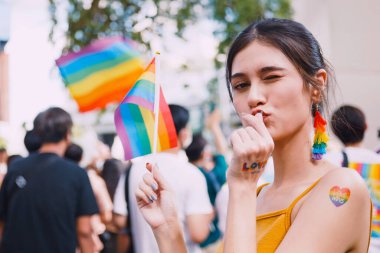 A young woman with rainbow tattoo stickers and showing symbols of homosexuality in pride parade. clipart