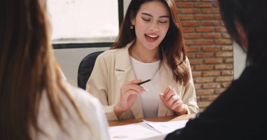 Kendine güvenen iş kadını, şirket toplantısı sırasında fikir paylaşıyor ya da iş projelerini meslektaşlarına anlatıyor.