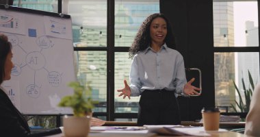 Şirket semineri sırasında iş arkadaşlarıyla veya seyircilerle fikir alışverişinde bulunan kendinden emin genç iş kadını ya da konuşmacı.