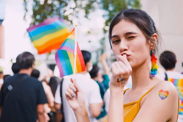 一名年轻女子带着彩虹纹身贴纸 在骄傲游行中展示同性恋的标志 — 图库照片
