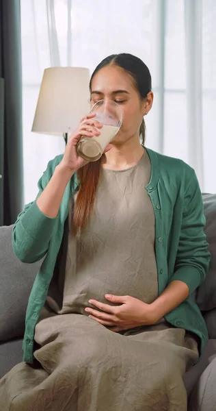 Asian pregnant woman drinking milk for the health of herself and her unborn baby.