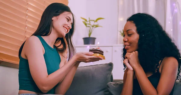 年轻的女人在家里用蛋糕给女朋友一个惊喜 女同性恋者夫妇在客厅庆祝生日 — 图库照片