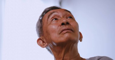 Alzheimer hastası Asyalı yaşlı adam evde tek başına oturuyor..