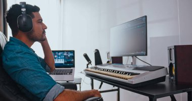 Asyalı müzisyen kendi stüdyosunda yeni müzik yapıyor. Bir besteci bir melodi yaratmak için modern ekipman kullanıyor..