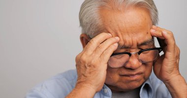 Migren ağrısı olan Asyalı yaşlı bir adam. Yaşlı adam baş ağrısı çekiyor..