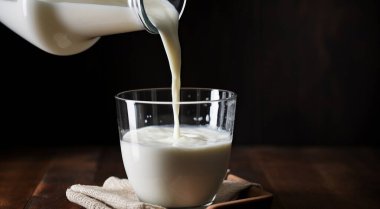 Bir bardak süt, bardağa dökülen süt, masaya konan bir bardak süt, koyu arka planda kalan bir bardak süt,