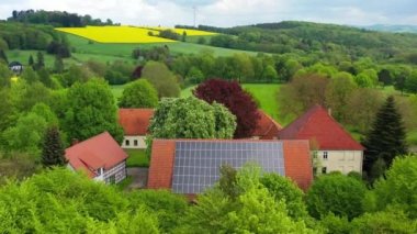 Almanya 'daki özel kır evlerinde hava aracı görüntüsü çatısı güneş panelleri. Yeşil yenilenebilir enerji, elektrik ekolojisi yeniliği. Yüksek kalite 4k görüntü