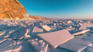Donmuş kış gölü Baykal Sibirya Rusya. Karda buz kalıpları ve uğultular. Mavi şeffaf buz üzerinde güçlü rüzgar ve kar fırtınası. Doğal soğuk arka plan. Kış soyut geçmişi. Yüksek kalite