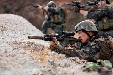 Fully Equipped Soldiers Wearing Camouflage Attacking Enemy, Rifles in Firing Position. Military Operation in Action, Squad On Fight, Pointing Rifle At Side, Concentrated. Focus On Serious Male