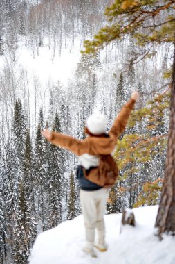 Rear View On Unrecognizable Traveller Woman With Backpack Standing On Top Of Mountain Enjoying The Landscape,Active Healthy Lady In Stylish Warm Outfit Look Around, Spreading Arms At Side