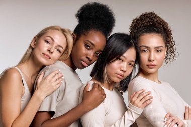 Diversity, multi-ethnic beauty concept. Four beautiful ladies of different races, African, Asian and Caucasian, with natural makeup, posing on studio background, standing in row. beauty concept