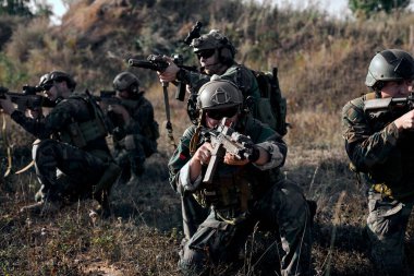military forces, Army soldier in protective combat uniform holding special operations forces combat assault rifle, Army military in protective combat uniform, Team of soldiers engaged.