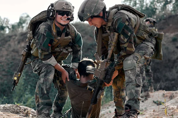 Soldiers rescue wounded soldier from battlefield.Military men in heavy combat ammunition drag injured partner to hospital.Armed conflict background.Swat officers fight back with automatic rifles