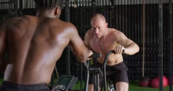 Schwarzafrikanische Und Kaukasische Männer Beim Cardio Workout Auf Einem Fahrrad — Stockvideo