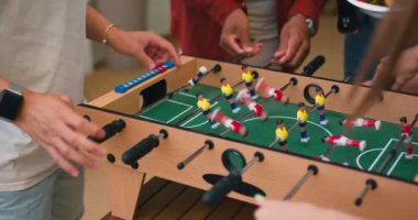 İnsanların kollarına yakın çekim, masa futbolu oynayan arkadaşlar birlikte futbol oynarken eğleniyorlar. İnsanlar masa futbolu oynamaktan hoşlanıyor. Masa futbolu takım oyunudur, mola, ilginç eğlence. Yavaş çekim