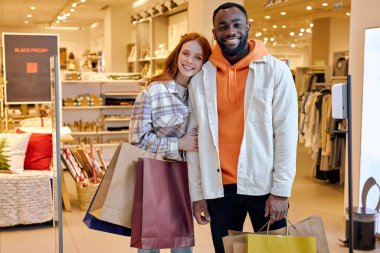 Moda kıyafetli güzel bir çift modern alışveriş merkezinde kameraya bakarak zaman geçirir. İnsanlar konsept, çevrimdışı alışveriş