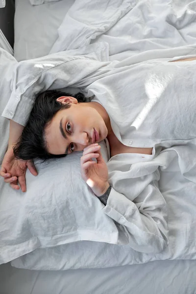 休憩を取る素晴らしいモデル トップビューの男は彼の手で頭の上にベッドに横たわっているだけで眠りに落ちる — ストック写真