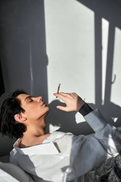 Χαλαρός Νεαρός Άνδρας Παίρνει Ευχαρίστηση Από Κάπνισμα Κάθεται Στον Καναπέ — Φωτογραφία Αρχείου