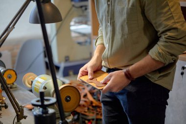 Erkek elleri Deri Parlatma Makinesi Deri Deri Tırnak Öğütme Makinesi ile çalışıyor. Kırbaçlar yan görüş açısını kapatıyor.