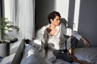 Siyah saçlı tembel öğrenci derslere katılmak, konferans vermek, yatağa oturmak istemiyor. Yana bakıyor. İnsanlar partiler ve tatiller yüzünden bitkin düşüyor.