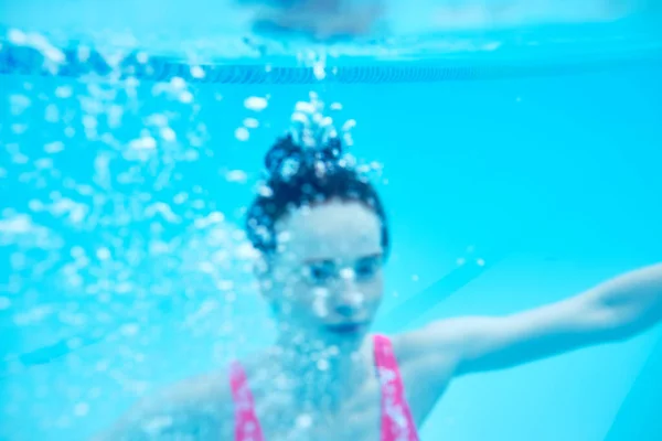 多くの泡とピンクの水着の若い女性が水中で 前景がぼやけている 肖像画を閉じて海に沈む少女死 — ストック写真