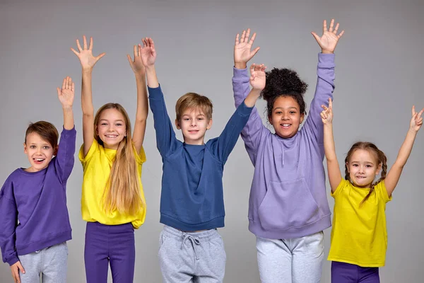 Groep Vrolijke Kinderen Trok Zijn Handen Omhoog Geïsoleerde Grijze Achtergrond — Stockfoto