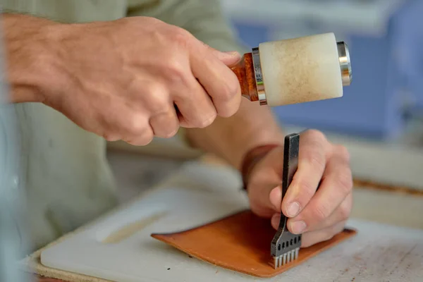 stock image guy Punching Holes in Leather for Stitching, close up cropped side view shot.hand stitching process. preparing material for hand stitching.
