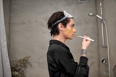 tapılası gay yüz derisini halleder, adam krem sürer, yan görünüm portresini kapatır..