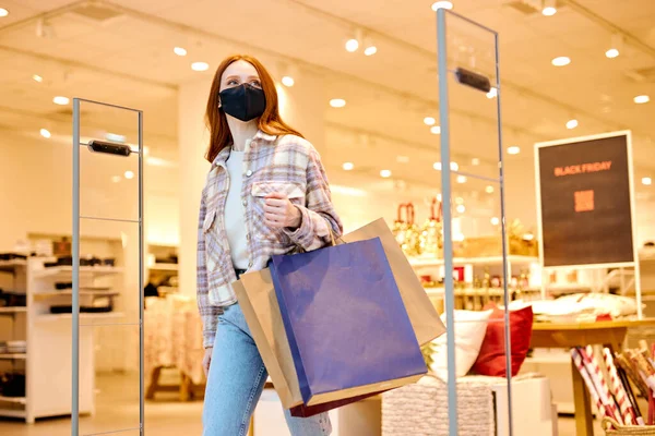 快乐快乐的姜汁女买家在购物中心购物后戴着防护面罩抵御考罗纳维 侧视图 — 图库照片