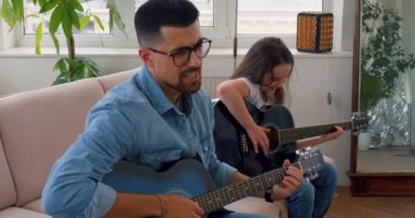 Yakışıklı duygusal adam şarkı söylemeyi, gitar çalmayı, erken eğitim için müzik dersinde eğlenmeyi seviyor. Eğlenceli öğrenme, boş zaman mutlu çalışma. Kız müzik aleti tutuyor, ağır çekimde gülümsüyor