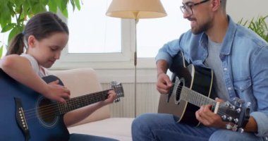 Genç kız ve öğretmeni evde gitar çalıyorlar, kız bazı temel akorları öğrenmekten zevk alıyor. İlk şarkı, yavaş hareket. Parmak egzersizleri. Parmak karıştırma becerileri..