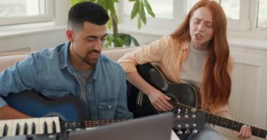 İki genç insan online müzik dersi, canlı konser, performans, eğitim, yaşam tarzı, teknoloji, ikili kayıt şarkısı tekle.slow motion, çift dizüstü bilgisayar video dersinde telli çalgıları öğreniyor