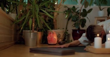 Sarışın, esnek bir kadının yakın plan çekimleri. Yoga yapıyor. Rahat bir oturma odasında köpeğe poz veriyor. Yavaş çekim, esneklik, yaşam tarzı, vücut bakımı, esnek kaslar ve eklemler.