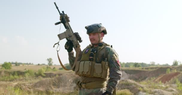 Ένας Χαμογελαστός Γενειοφόρος Στρατιώτης Κρατώντας Όπλο Του Ψηλά Υψώνοντας Αυτόματο — Αρχείο Βίντεο