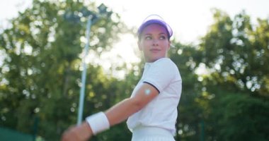 Genç, zayıf, kendine güvenen, sportif kadın şapkaya dokunuyor, raketle sahada poz veriyor. Boş zaman yaşam tarzı yavaş çekim pozitif tutum oyun konsantrasyon motivasyonundan önce