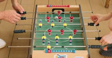 Erkek ve kadın kolları masa futbolu oynuyor. Takım çalışması eğitim aktivitesi. Çocukluk. Spor. Yakın plan. Yan görüş. Ağır çekim eğlence