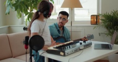 Müzik, şarkı söyleyen ve şarkıcı kız sakallı adam, kayıt stüdyosunda kulaklık mikrofonuyla podcast, ses testi ses prodüksiyonu için. Ünlülük, yetenek avcısı veya ev stüdyosundaki genç müzisyen.