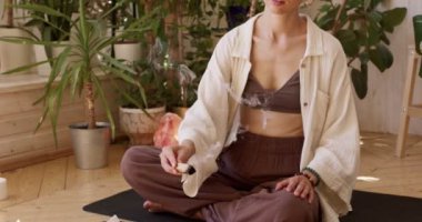 Kadın, Palo Santo 'yu kullanarak meditasyon için odasını hazırla. Kesik kesik ağır çekimde, kız acı ve stresi tedavi ediyor, temiz negatif enerji. Tören