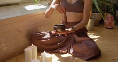 fit kız meditasyondan sonra Tibet şarkı kasesi çalar. Sportif kız ruhani çalışma sırasında ayakta çan kullanıyor. Ses terapisi, yavaş hareket. Stres rahatlama. Depresyonu azaltma.