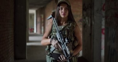 Sıra dışı kamuflajlı genç bir askeri kadın hedef alınıyor, avcı avı izliyor, asker ağır çekimde ateş etmeye hazırlanıyor, kadın asker tüfek kullanıyor.