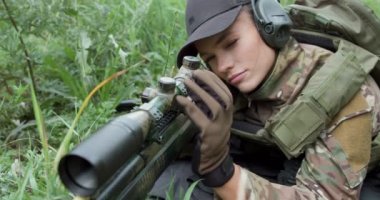 Sırtında çantasıyla savaş oyunundan zevk alan genç ve güzel bir kadın, elinde tüfekle mutlu bir kız, kahkaha, yaşam tarzı hobisi, ilgisiz boş zaman yavaş çekim. Kadın askeri operasyon sırasında.