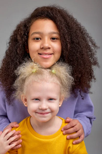 有魅力的黑人姑娘把她的手放在朋友的肩上 黑人小孩照顾她的小妹妹 — 图库照片