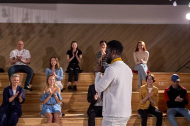 İş toplantılarında konferans salonunda hoş afro erkek konuşmacı konuşma yapıyor. Konferans salonunda ders dinleyen bir grup insan. İşletme ve girişimcilik. Boşluğu kopyala