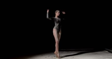 Toz konseptiyle dans etmek. Toz içinde güzel beyaz kadın dansçı, siyah tulum giymiş, izole edilmiş siyah stüdyo arka planında un bulutu içinde dans eden kadın dansçı. sanat, performans
