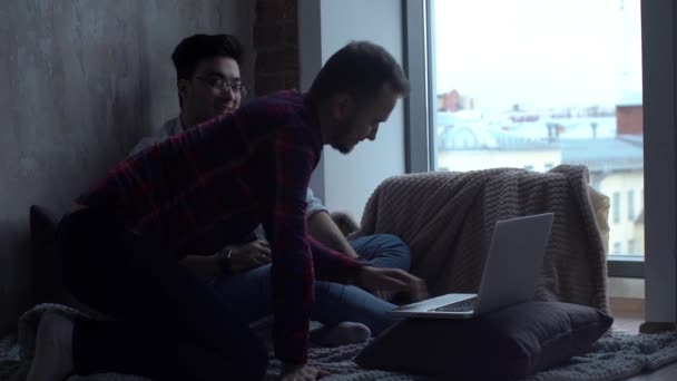 坐在家里为同性结婚仪式选择戒指的同性恋男性夫妇 使用在线购买服务 — 图库视频影像